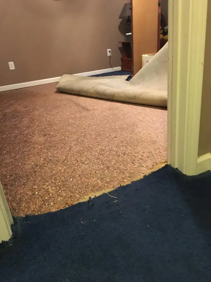 Carpet pad removal revealing water damage during Water Mitigation Services in Yonkers